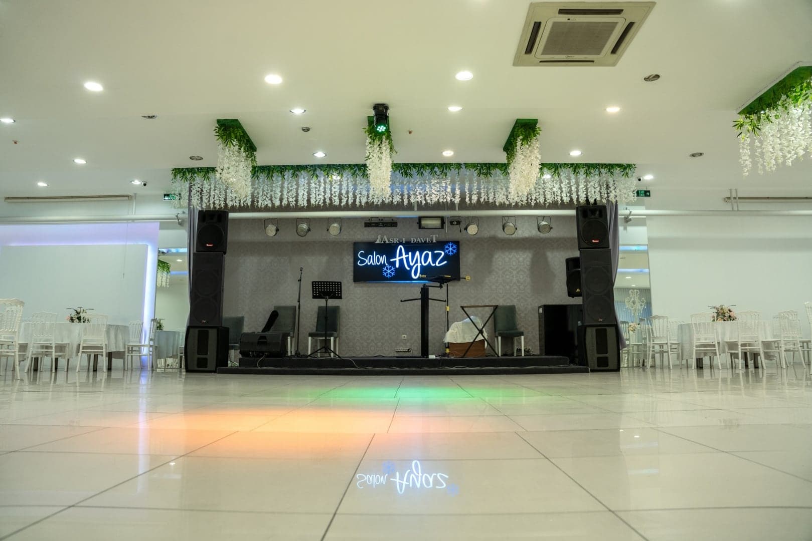 Salon Ayaz sahnesinde ses sistemi ve ışıklı parlak zeminli dans alanı