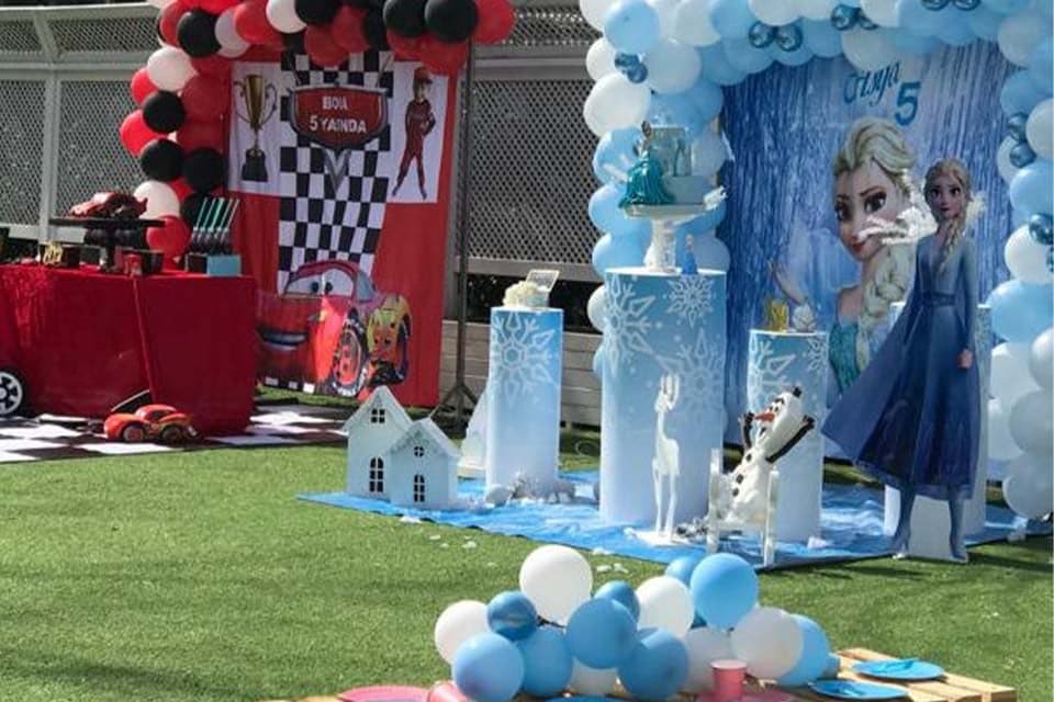 Çim zemine kurulmuş balon kemerli çocuk doğum günü süslemesi