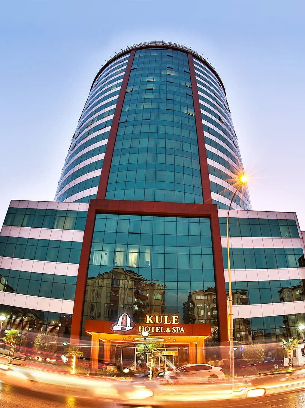 Kule Hotel & Spa'nın alacakaranlıkta ışıklandırılmış cam cepheli kule binası