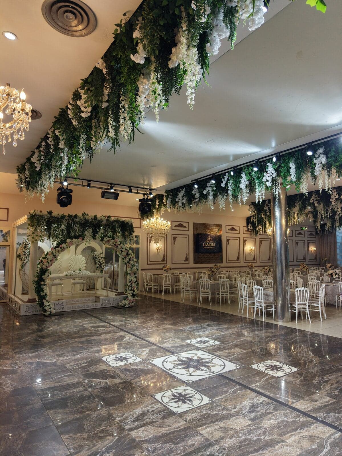 Silver Salon'da tavandan sarkan yeşillik ve çiçekler altında mermer desenli dans pisti