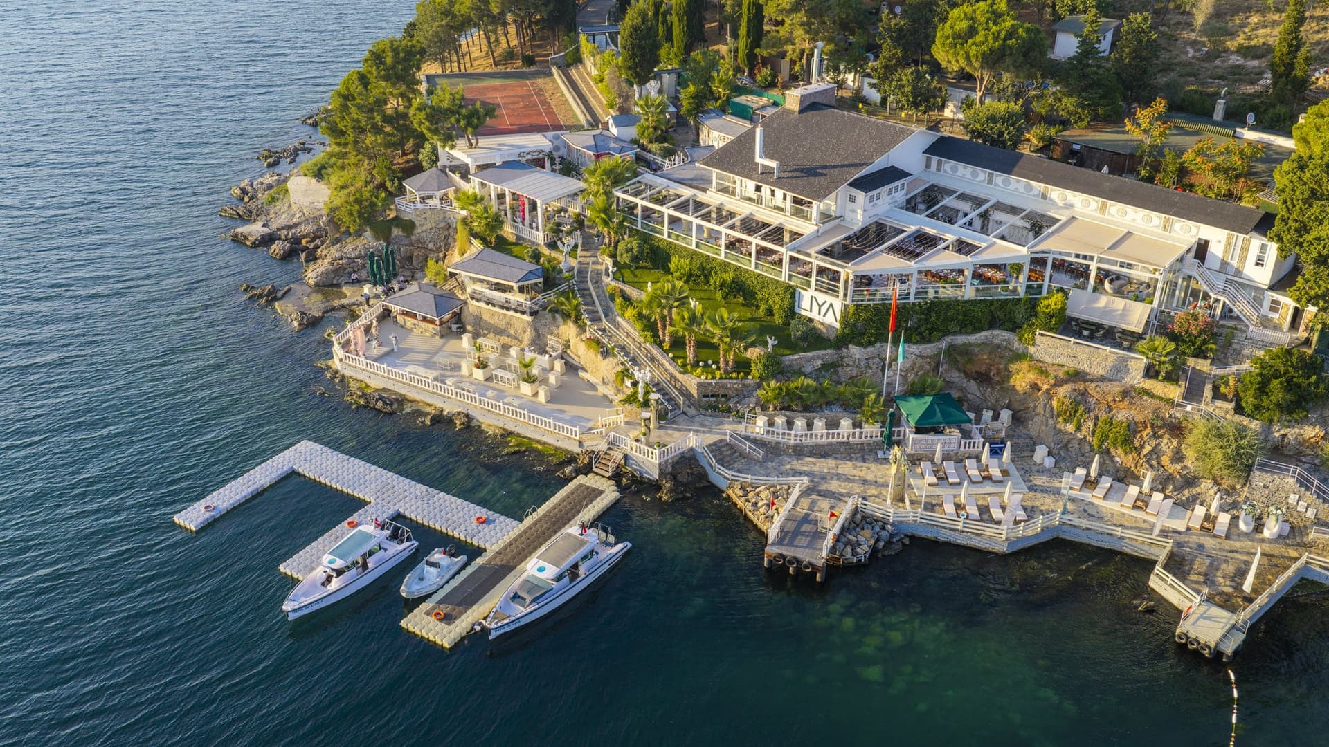 Liya All'ın Sedef Adası kıyısındaki binaları ve iskeleye bağlı tekneler, kuşbakışı