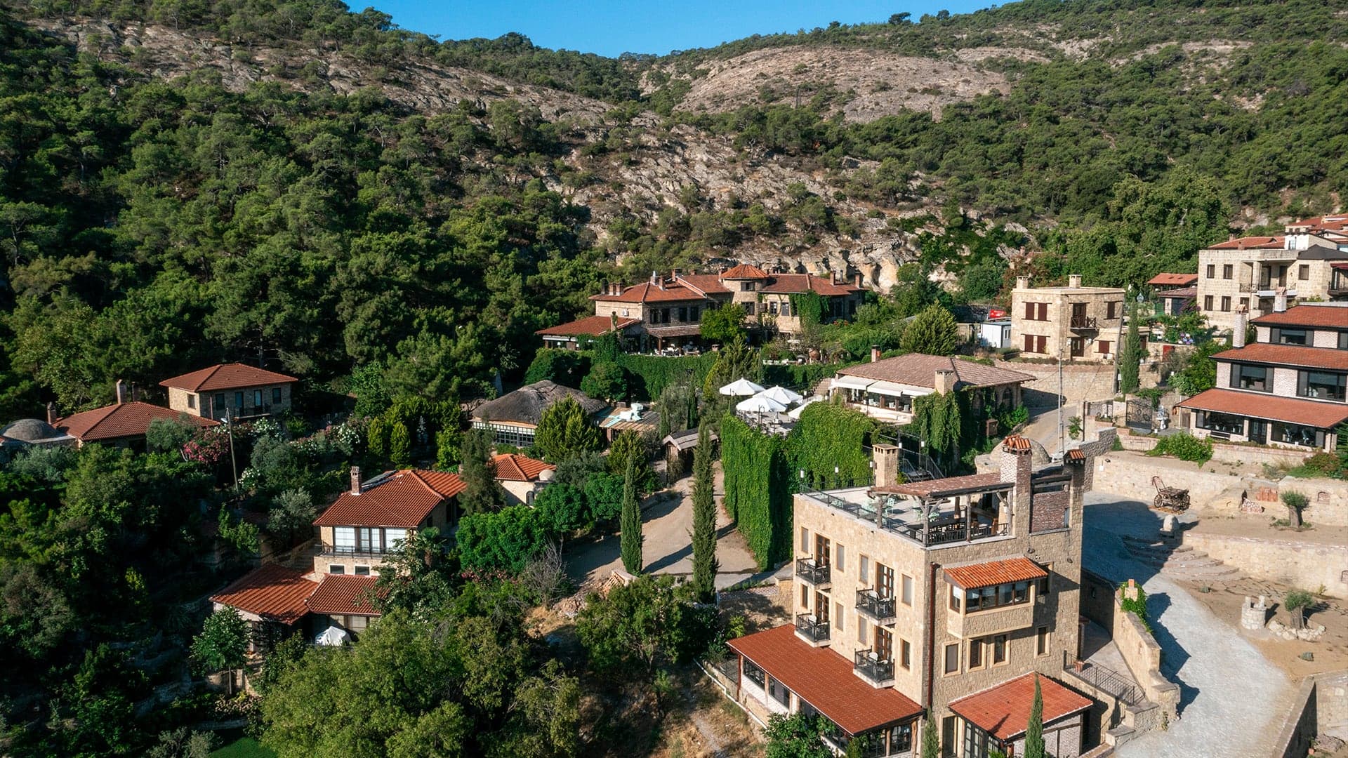 Yeşilyurt Köyü'nün taş evleri ve ağaçlarla kaplı tepeler, havadan görünüm