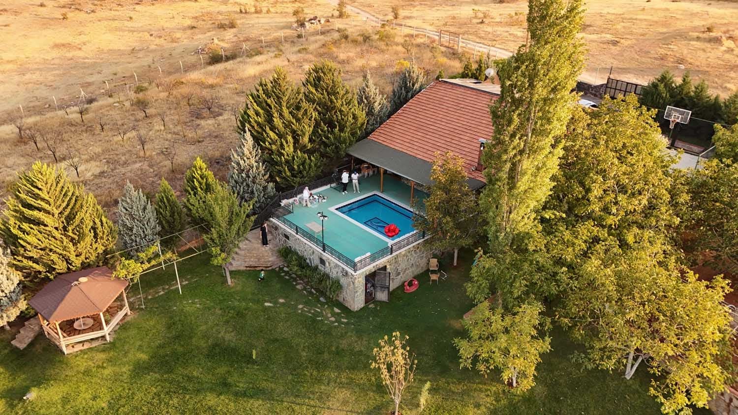 Sarısalkım'daki Villa-1'in havuzu, bahçedeki çardak ve çevresindeki ağaçların havadan görünümü