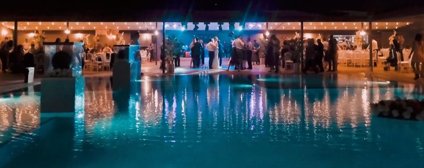 Gece havuz başında ışıklandırılmış davet alanı ve dans eden misafirler