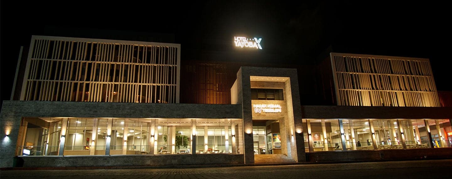 Hotel Yayoba binasının gece aydınlatılmış ahşap kaplı cephesi