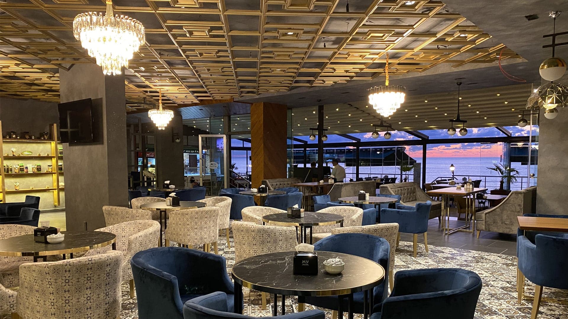 Deniz manzaralı pencerelerin önünde koltuklu restoran ve cafe alanı