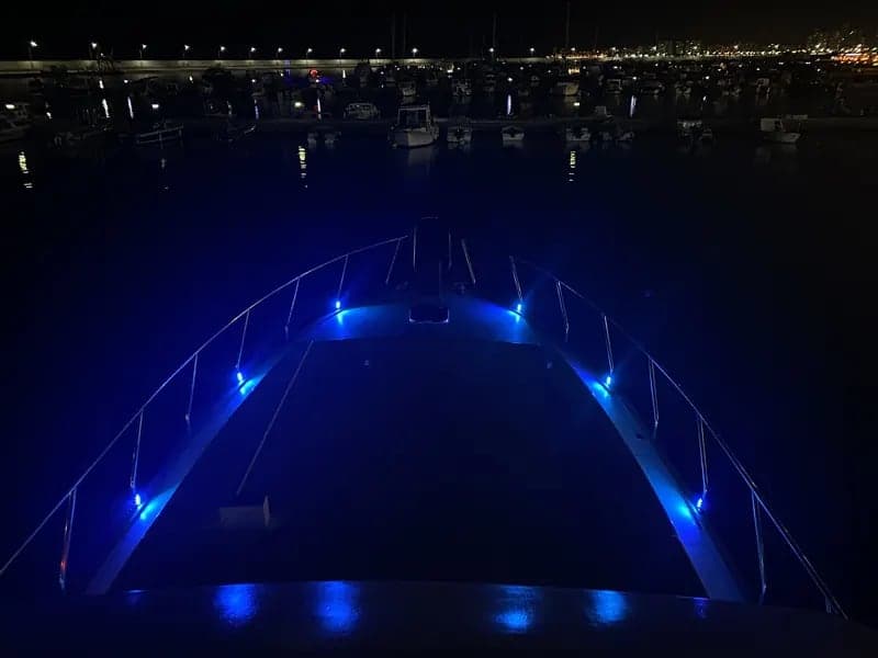 Gece limanda mavi ışıklarla aydınlatılmış motoryatın baş kısmı