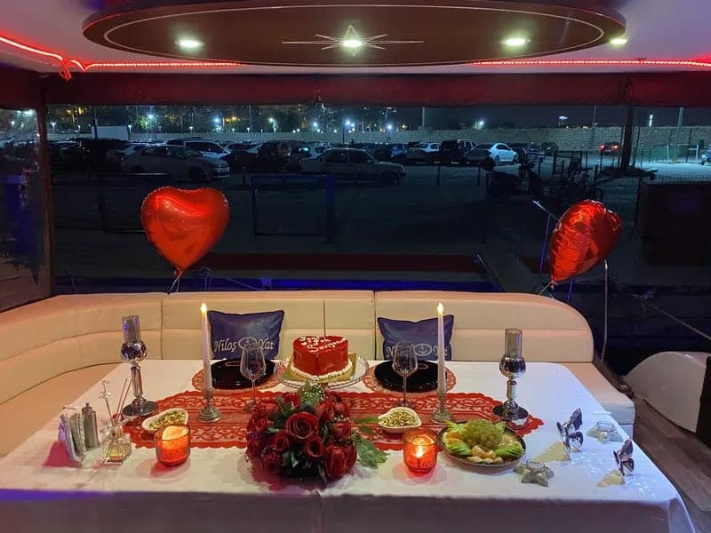 Kalpli balonlar, kalp biçimli pasta ve kırmızı güllerle hazırlanmış akşam masası