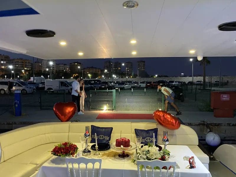 İskeledeki teknenin arka güvertesinde kırmızı balonlarla süslenmiş kutlama masası