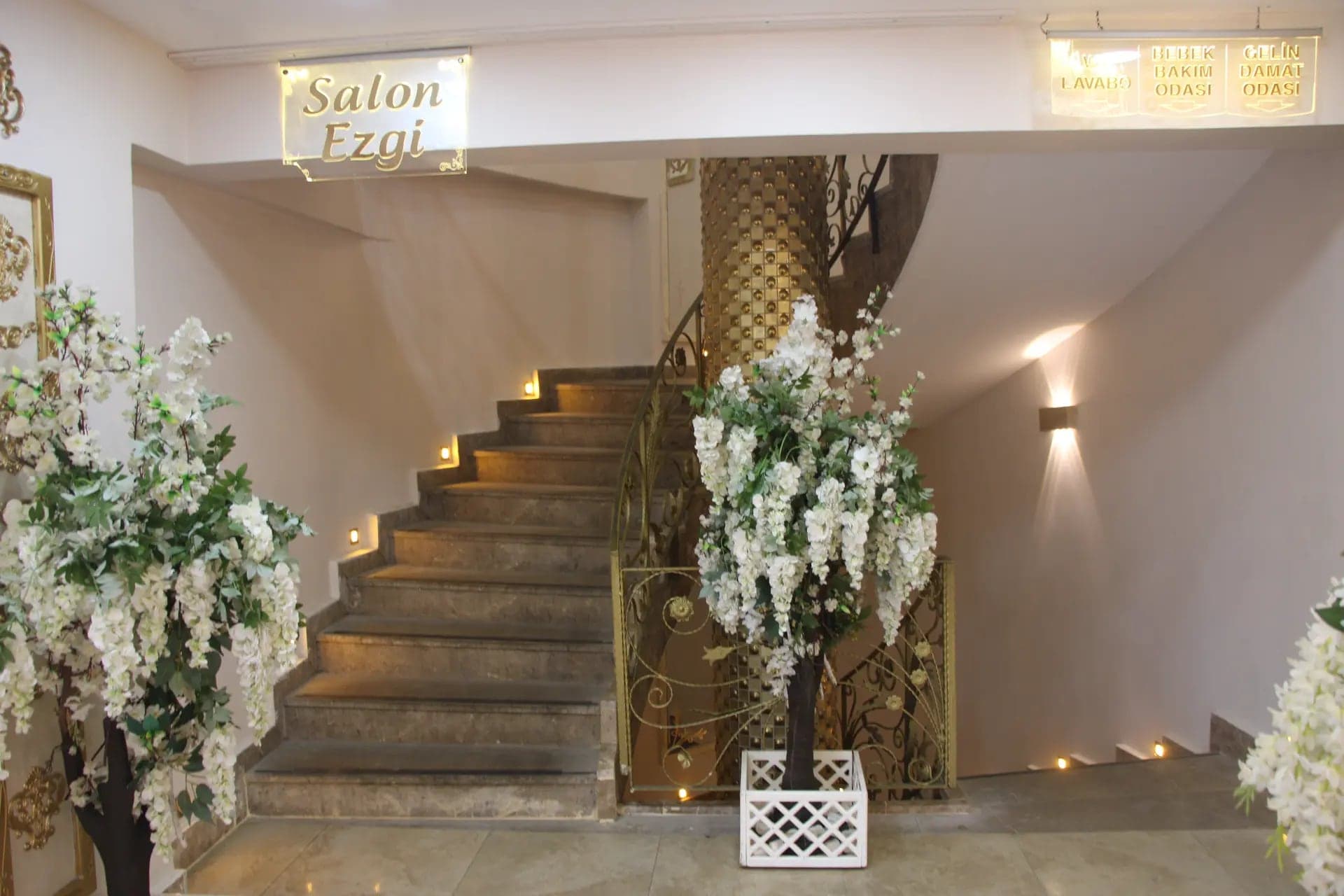 Çiçekli dallarla süslü, Ezgi Salon'a inen ışıklı merdiven